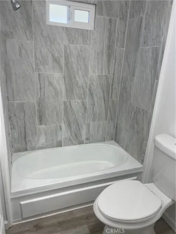 a bathroom with a toilet and bathtub
