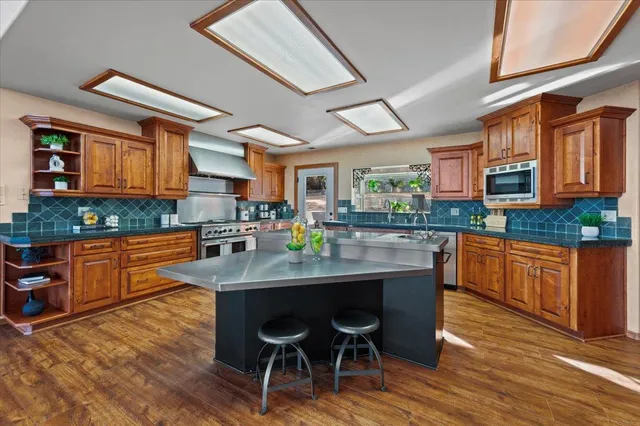 a kitchen with granite countertop a stove top oven cabinetry and granite counter top