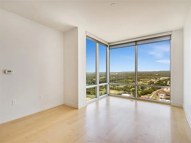 300 Bowie Street, Unit 2504 Austin, TX 78703 - Photo 5 of 10 Empty room featuring floor to ceiling windows and light wood-type flooring