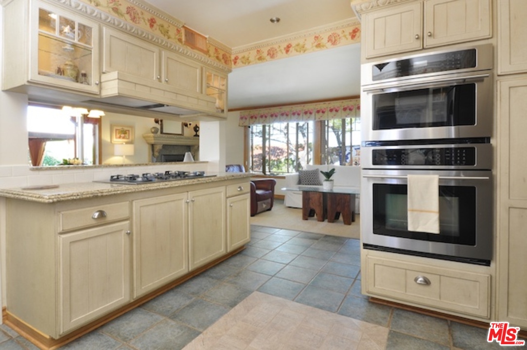 15098 Rayneta Drive Sherman Oaks, CA 91403 - Photo 24 of 51 a kitchen with stainless steel appliances granite countertop a stove microwave and a sink