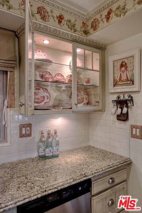 15098 Rayneta Drive Sherman Oaks, CA 91403 - Photo 26 of 51 a kitchen with granite countertop a stove a oven and wooden cabinets