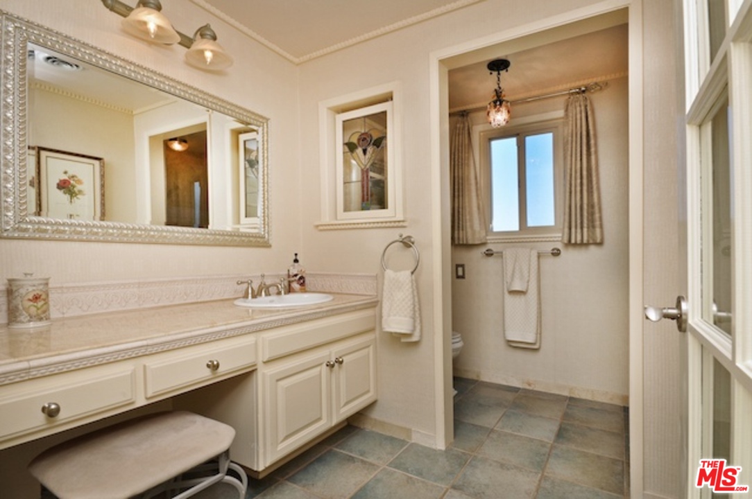 15098 Rayneta Drive Sherman Oaks, CA 91403 - Photo 29 of 51 a bathroom with a sink a mirror and a shower