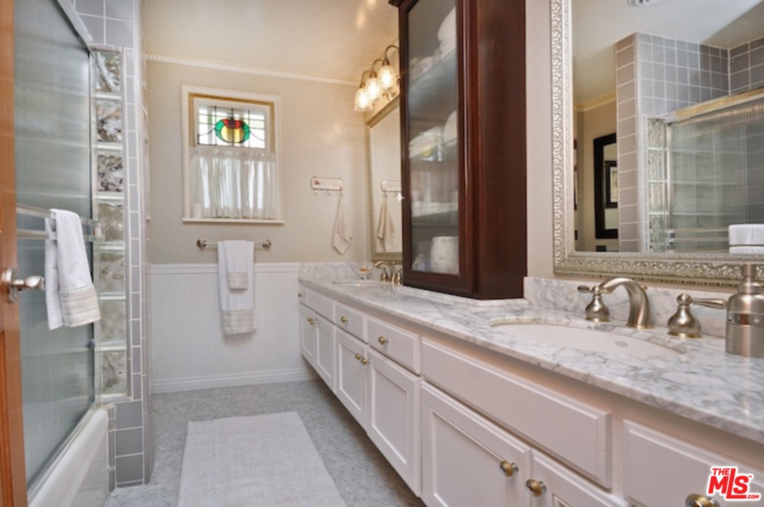 15098 Rayneta Drive Sherman Oaks, CA 91403 - Photo 43 of 51 a bathroom with a double vanity sink a mirror and a shower