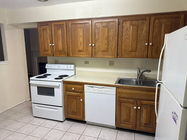 a kitchen with granite countertop cabinets and white appliances
