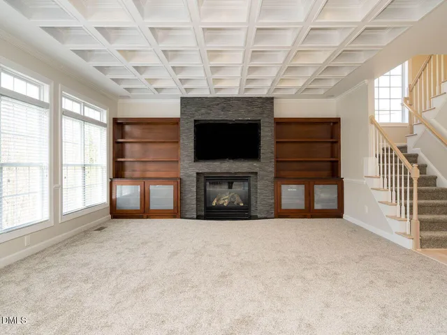a view of an empty room with a fireplace and a window