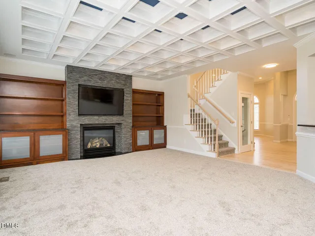 a view of an empty room with a fireplace and a window