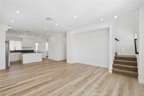 a kitchen with stainless steel appliances granite countertop a refrigerator a stove and a sink