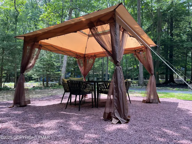 a view of a house with backyard and sitting area