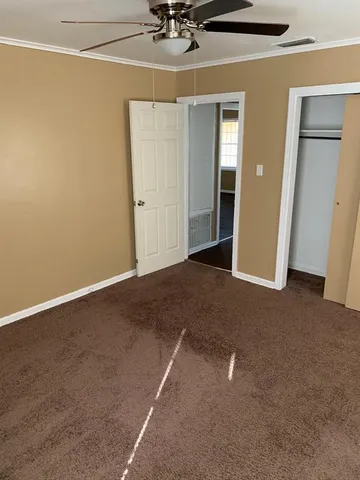an empty room with a ceiling fan and closet