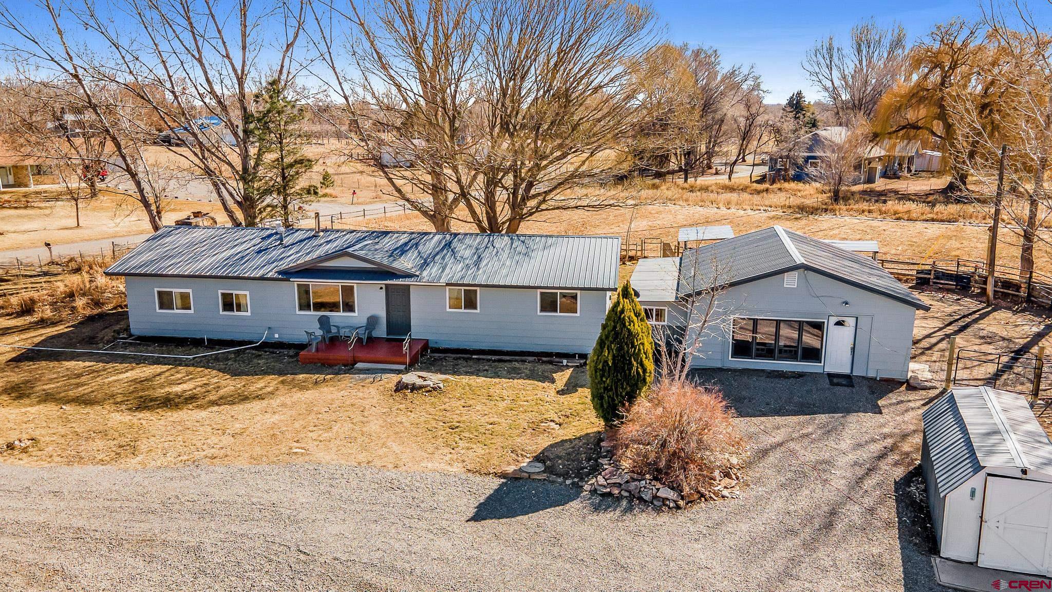 15098 6160th Road Montrose, CO 81403 - Photo 1 of 30 a front view of a house with a yard covered in snow