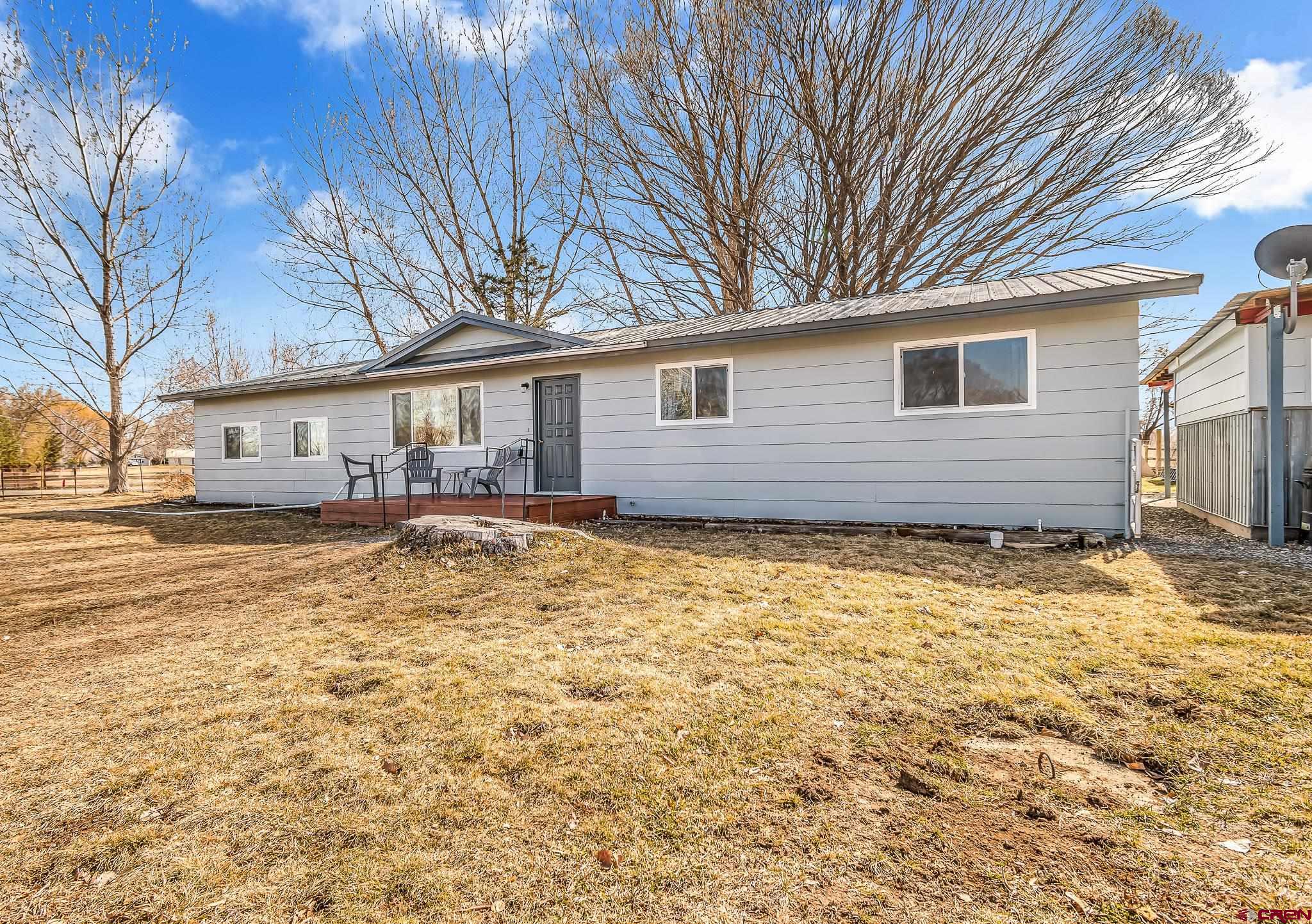 15098 6160th Road Montrose, CO 81403 - Photo 2 of 30 a front view of a house with a yard and garage