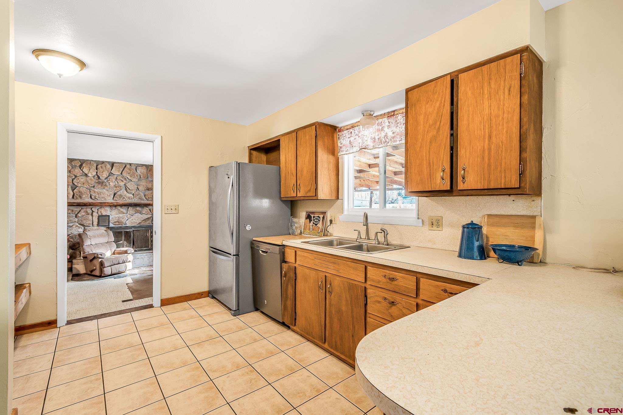 15098 6160th Road Montrose, CO 81403 - Photo 7 of 30 a kitchen with stainless steel appliances a sink cabinets and a window