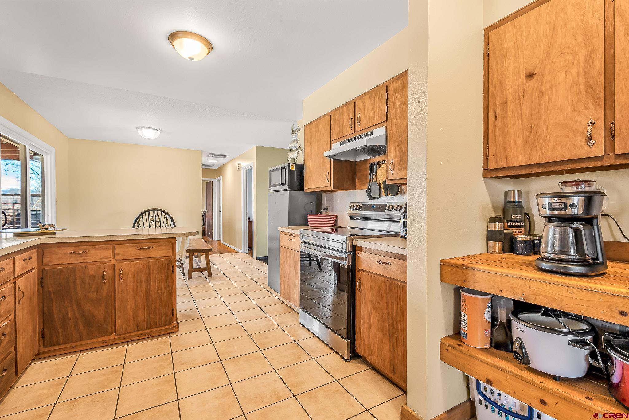 15098 6160th Road Montrose, CO 81403 - Photo 8 of 30 a kitchen with stainless steel appliances granite countertop a stove a sink and a microwave