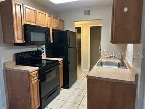1695 Lee Road, Unit C110 Winter Park, FL 32789 - Photo 6 of 12 a kitchen with a refrigerator stove and sink