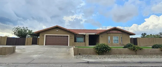 a view of a house with a yard and potted plants