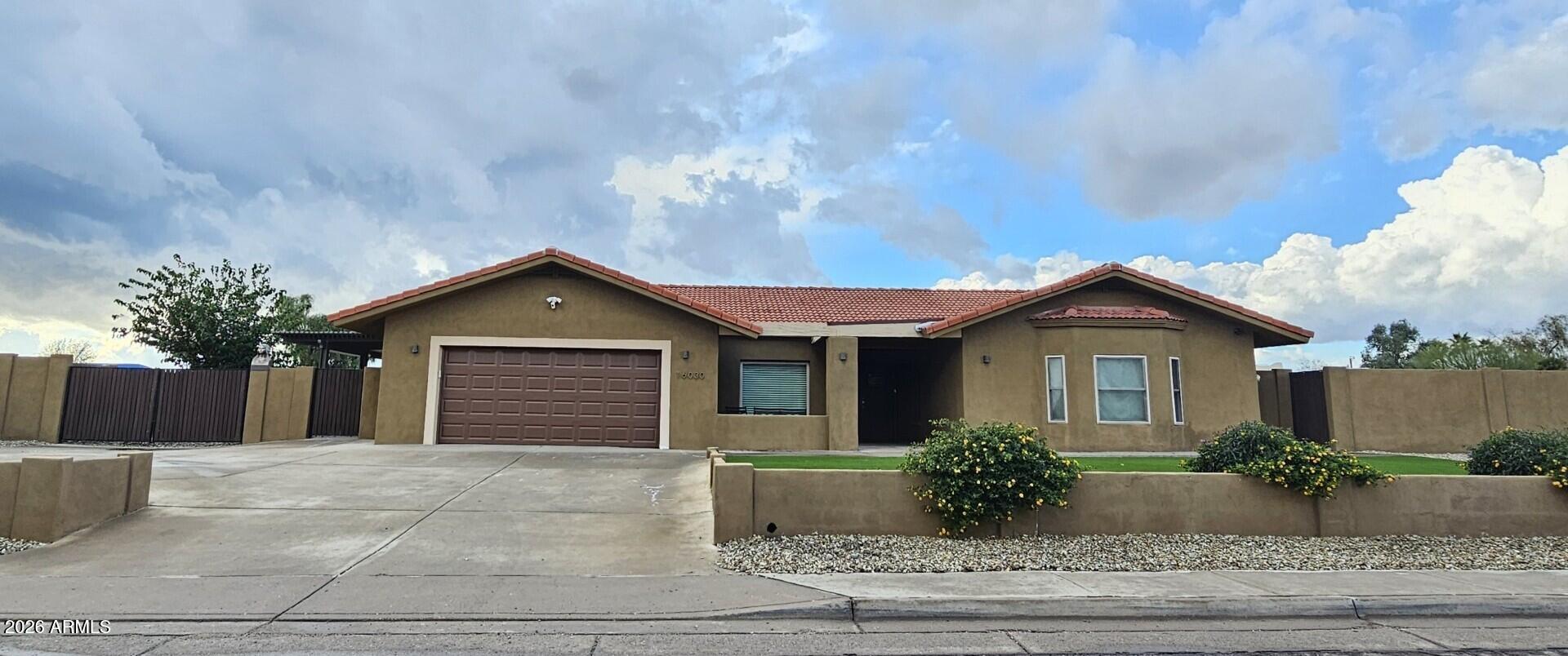 a view of a house with a yard and potted plants