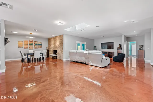 a living room with furniture and a dining table with wooden floor