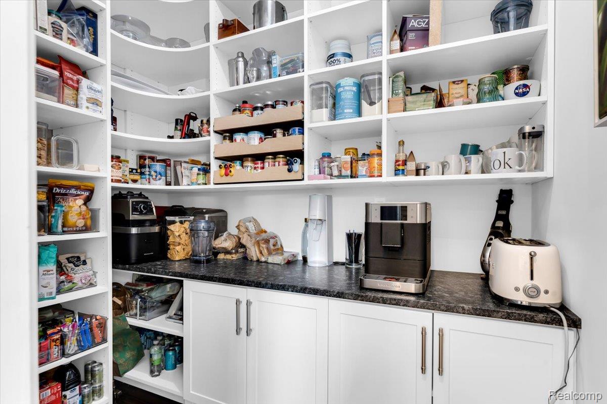 195 Baldwin Road Birmingham, MI 48009 - Photo 15 of 76 Built-in white shelving featuring a curved corner design, white cabinetry with brushed nickel hardware, and a dark stone-finish countertop