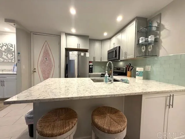 a kitchen with stainless steel appliances granite countertop a sink refrigerator and cabinets