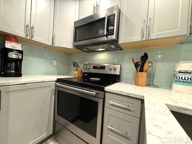 a kitchen with stainless steel appliances granite countertop a sink and a stove