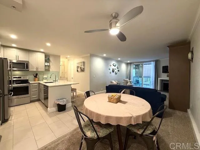 a kitchen with a dining table chairs stainless steel appliances and cabinets