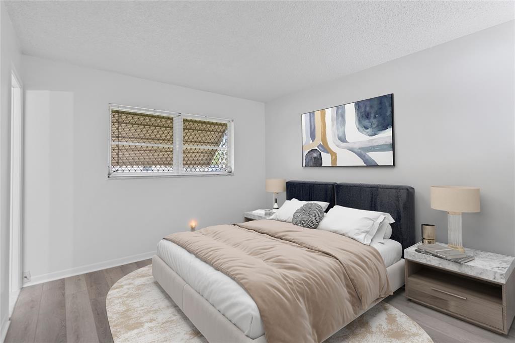 1230 Old Boynton Road, Unit 203 Boynton Beach, FL 33426 - Photo 2 of 25 a bedroom with a bed and a night stand