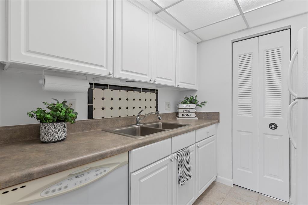 1230 Old Boynton Road, Unit 203 Boynton Beach, FL 33426 - Photo 3 of 25 a kitchen with white cabinets and sink