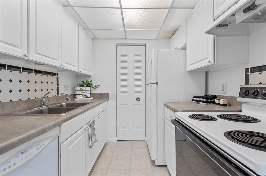 1230 Old Boynton Road, Unit 203 Boynton Beach, FL 33426 - Photo 4 of 25 a kitchen with stainless steel appliances granite countertop a sink stove and cabinets