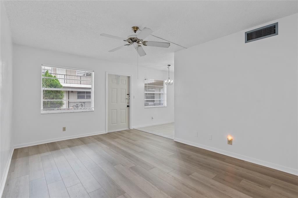 1230 Old Boynton Road, Unit 203 Boynton Beach, FL 33426 - Photo 9 of 25 a view of empty room with wooden floor and fan