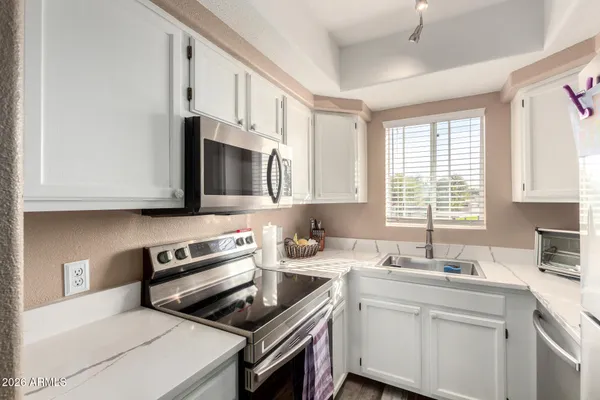 a kitchen with stainless steel appliances granite countertop a sink stove and microwave