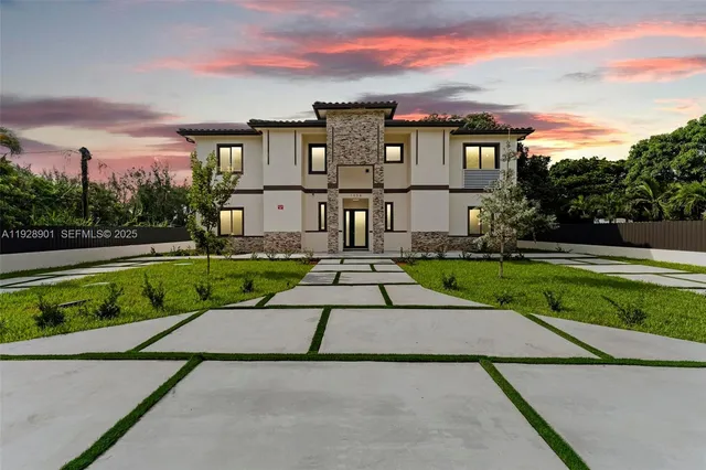 a view of a white house with a yard and plants