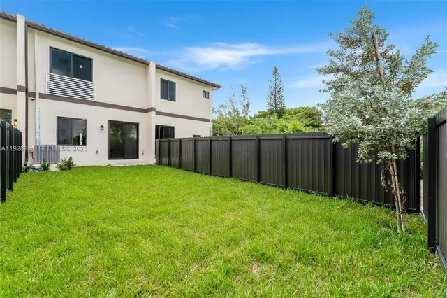 a view of a backyard with wooden fence