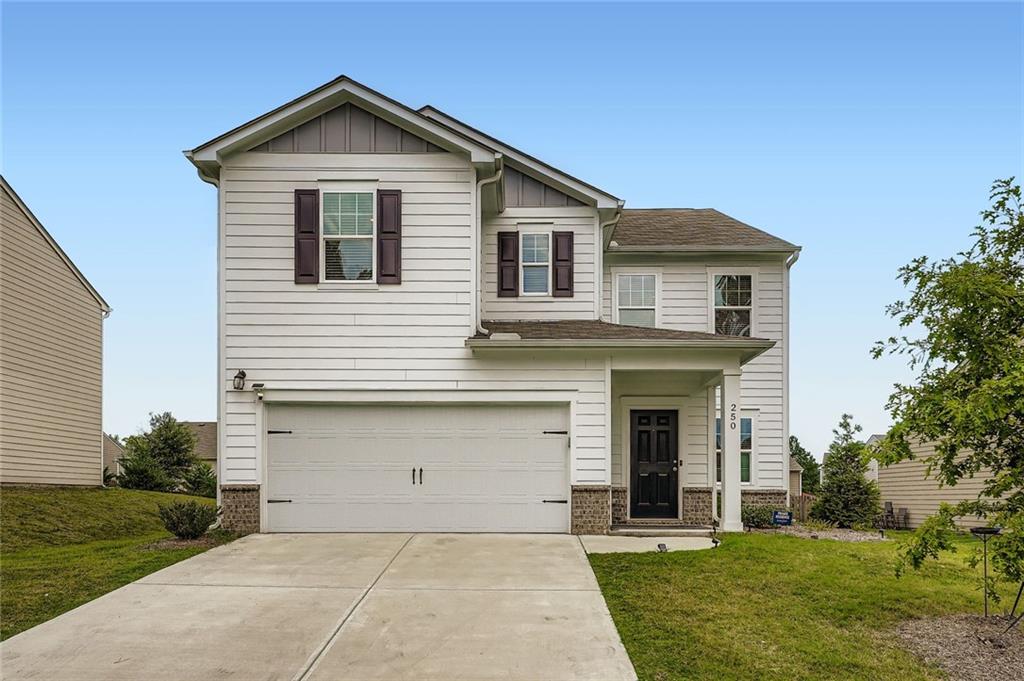 a front view of a house with a yard and trees