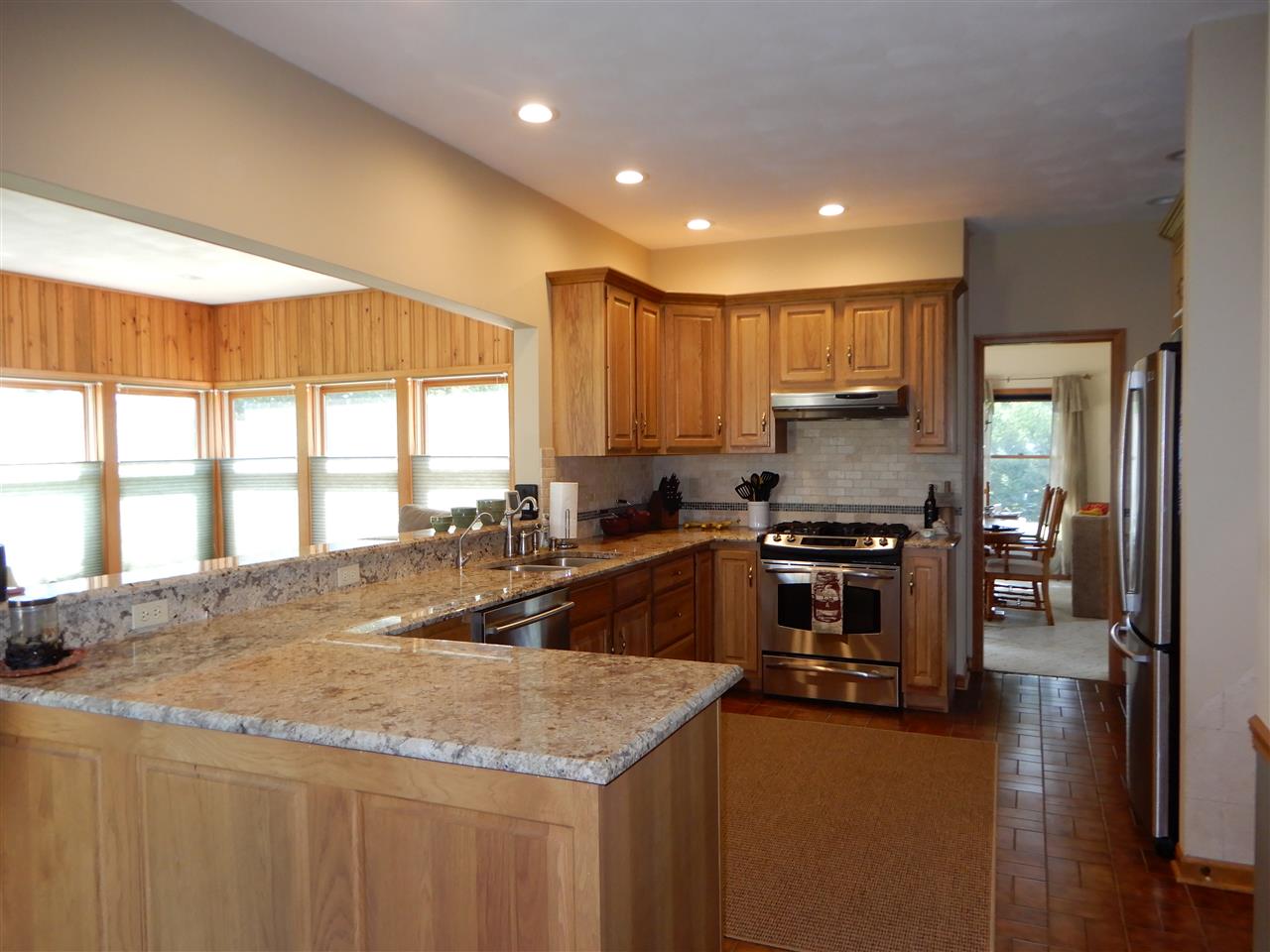 12145 Caledonia Road Belvidere, IL 61008 - Photo 3 of 25 a kitchen with stainless steel appliances granite countertop a sink a stove and a refrigerator