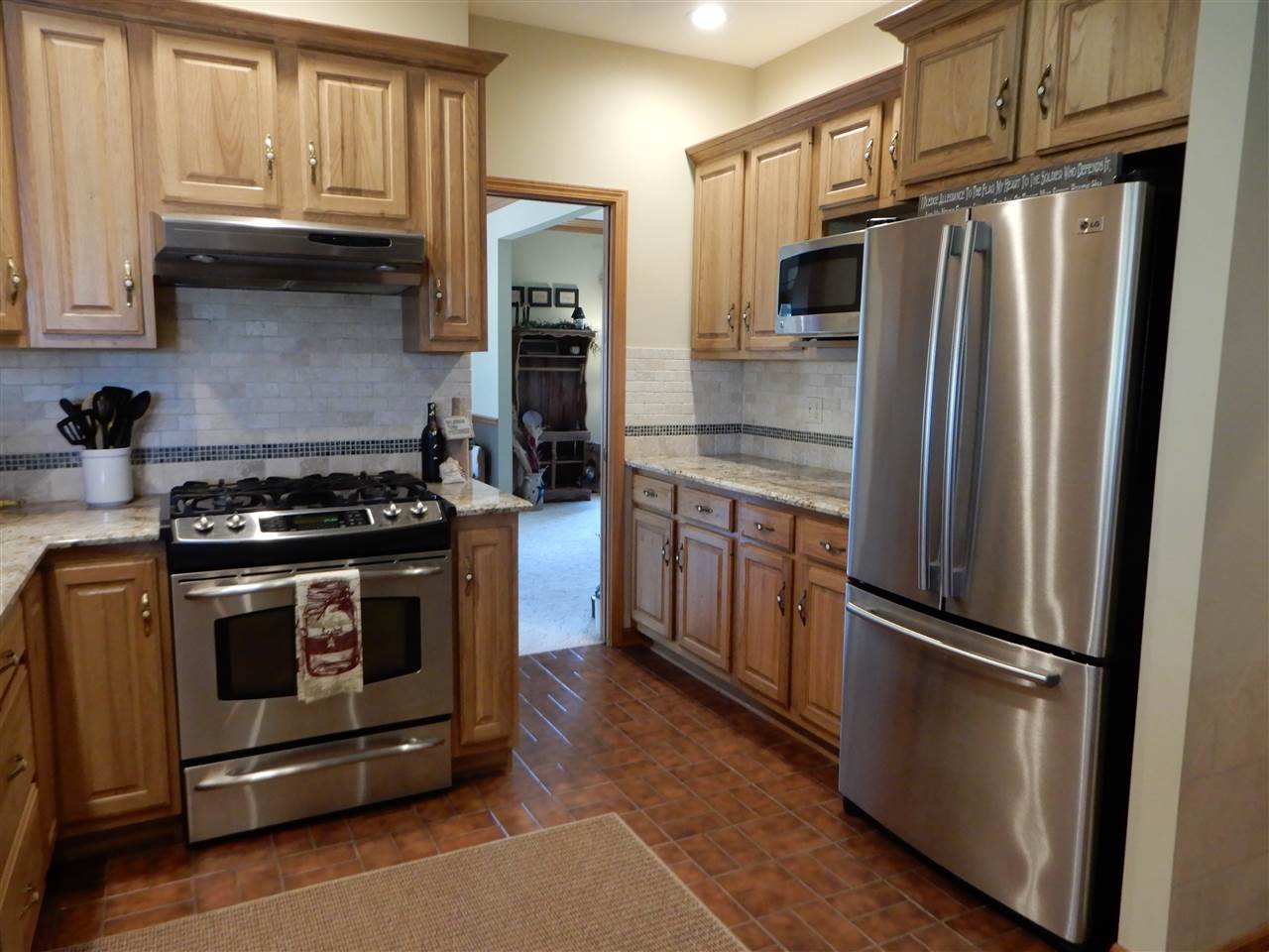 12145 Caledonia Road Belvidere, IL 61008 - Photo 4 of 25 a kitchen with stainless steel appliances granite countertop a refrigerator stove and sink