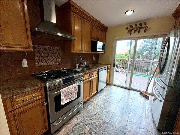 a kitchen with stainless steel appliances granite countertop a stove a sink and a microwave