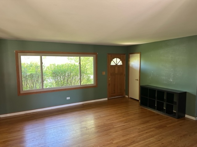 2217 West Palatine Road Inverness, IL 60067 - Photo 3 of 17 a view of an empty room with window and wooden floor