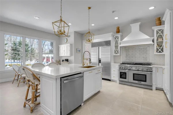 a kitchen with kitchen island a sink stove a refrigerator and a dining table with wooden floor