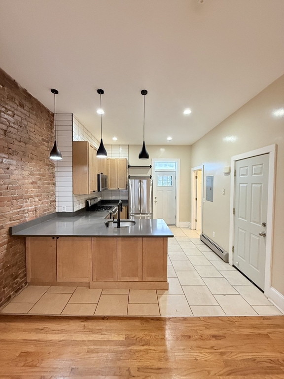 57 Coleman Street, Unit 2 Boston, MA 02125 - Photo 4 of 24 a large kitchen with stainless steel appliances kitchen island granite countertop a sink and cabinets