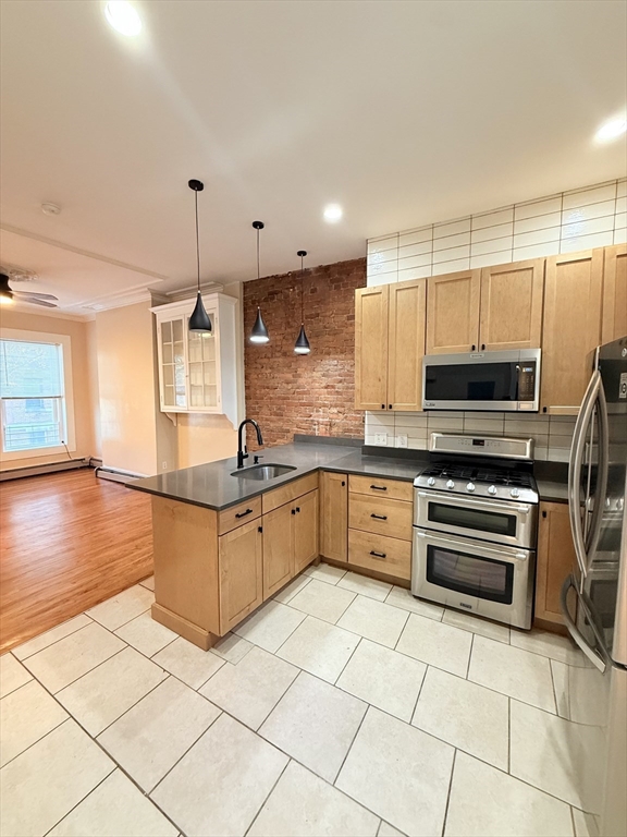 57 Coleman Street, Unit 2 Boston, MA 02125 - Photo 5 of 24 a kitchen with stainless steel appliances granite countertop a sink and a stove