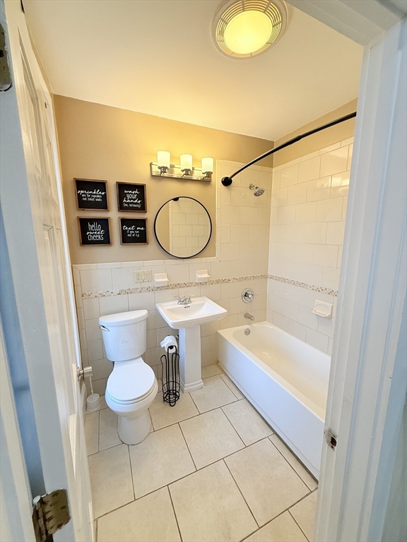 57 Coleman Street, Unit 2 Boston, MA 02125 - Photo 9 of 24 a bathroom with a sink a toilet a mirror and bathtub