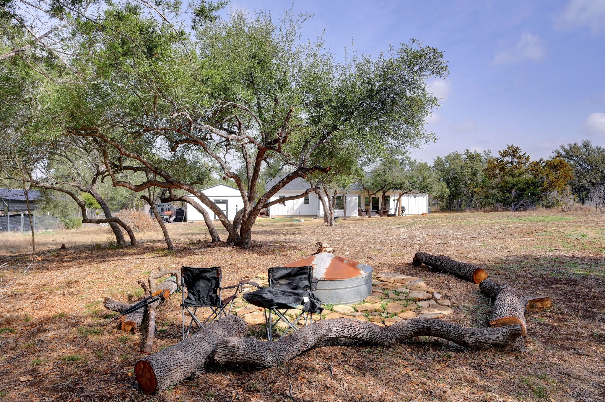 200 Rust Ranch Road Blanco, TX 78606 - Photo 22 of 26 a view of a backyard with table and chairs and a fire pit