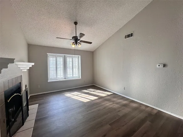 a view of empty room with fireplace and fan