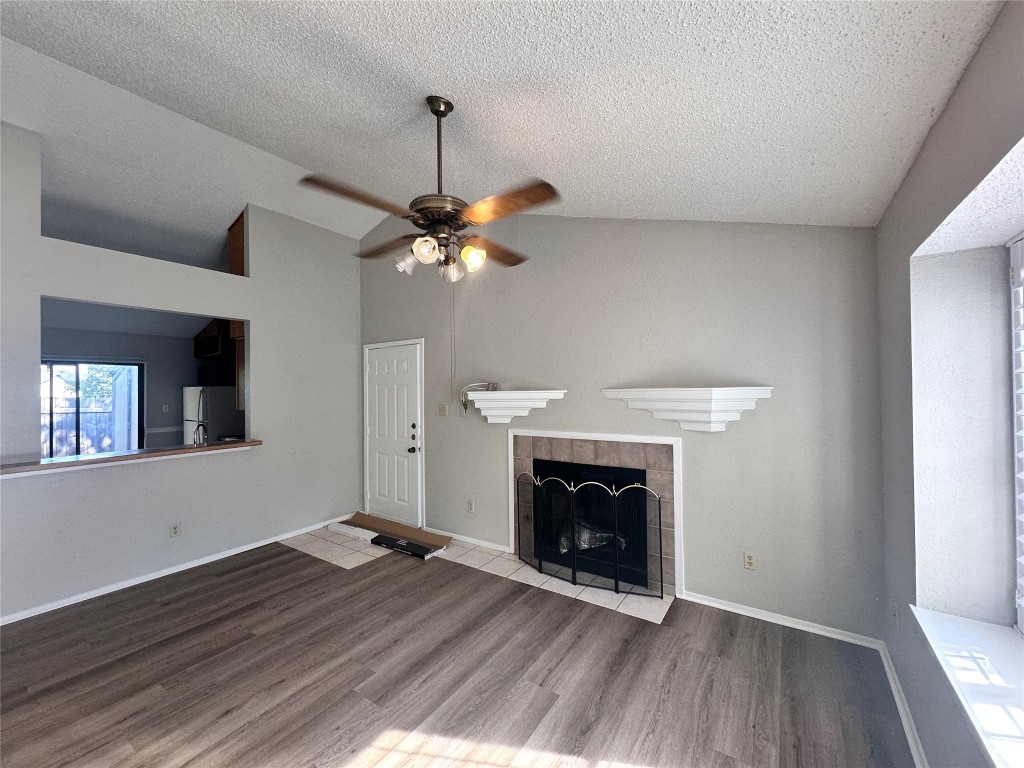 1411 Gracy Farms Lane, Unit 102 Austin, TX 78758 - Photo 2 of 12 a view of an empty room with wooden floor fireplace and a window