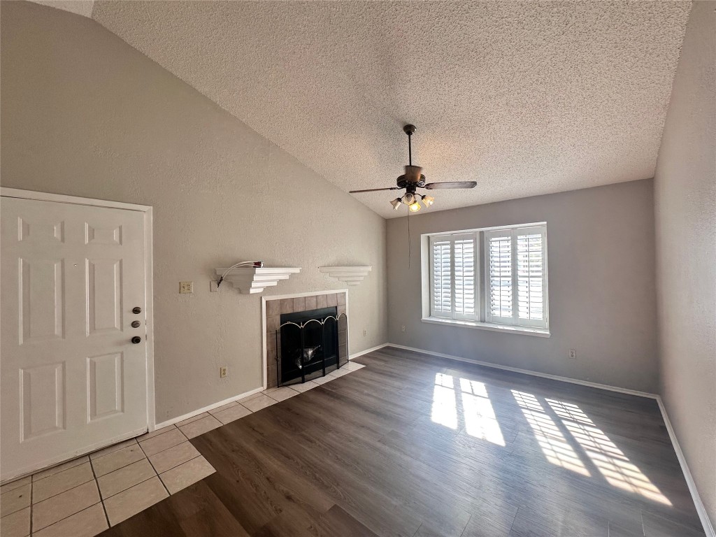 1411 Gracy Farms Lane, Unit 102 Austin, TX 78758 - Photo 3 of 12 a view of an empty room with wooden floor fireplace and a window