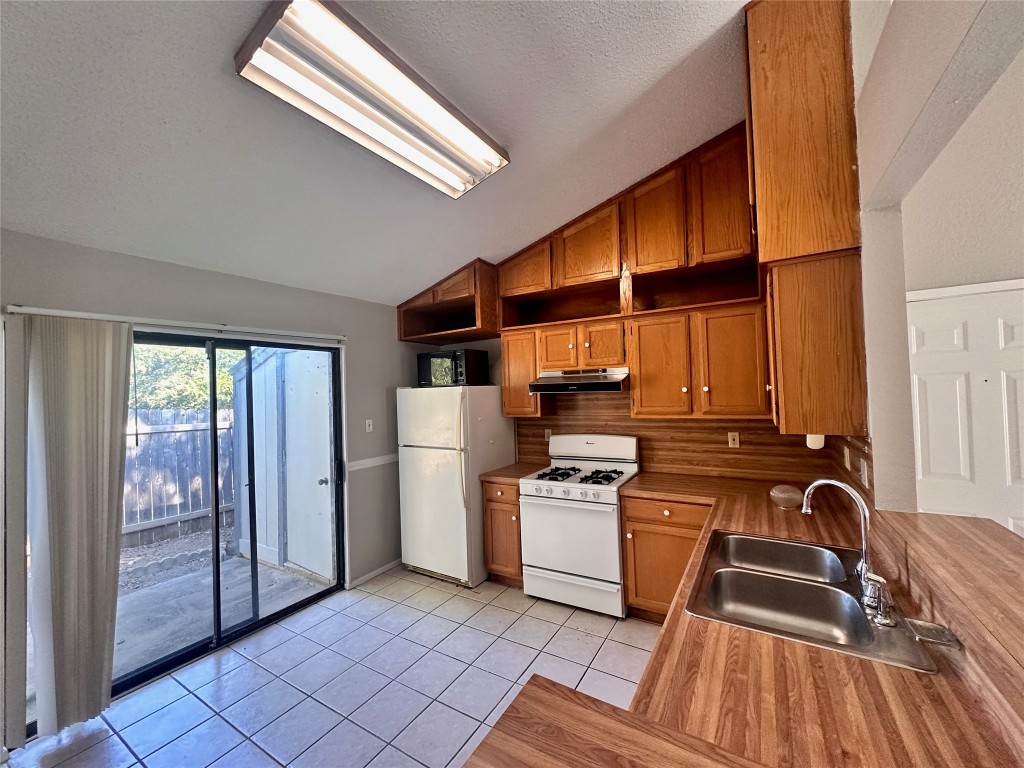 1411 Gracy Farms Lane, Unit 102 Austin, TX 78758 - Photo 5 of 12 a view of a kitchen with wooden floor and electronic appliances