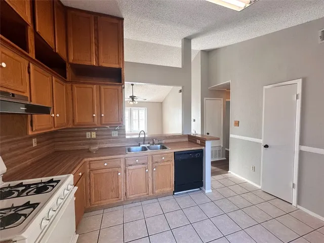a kitchen with a sink stove top oven and cabinets