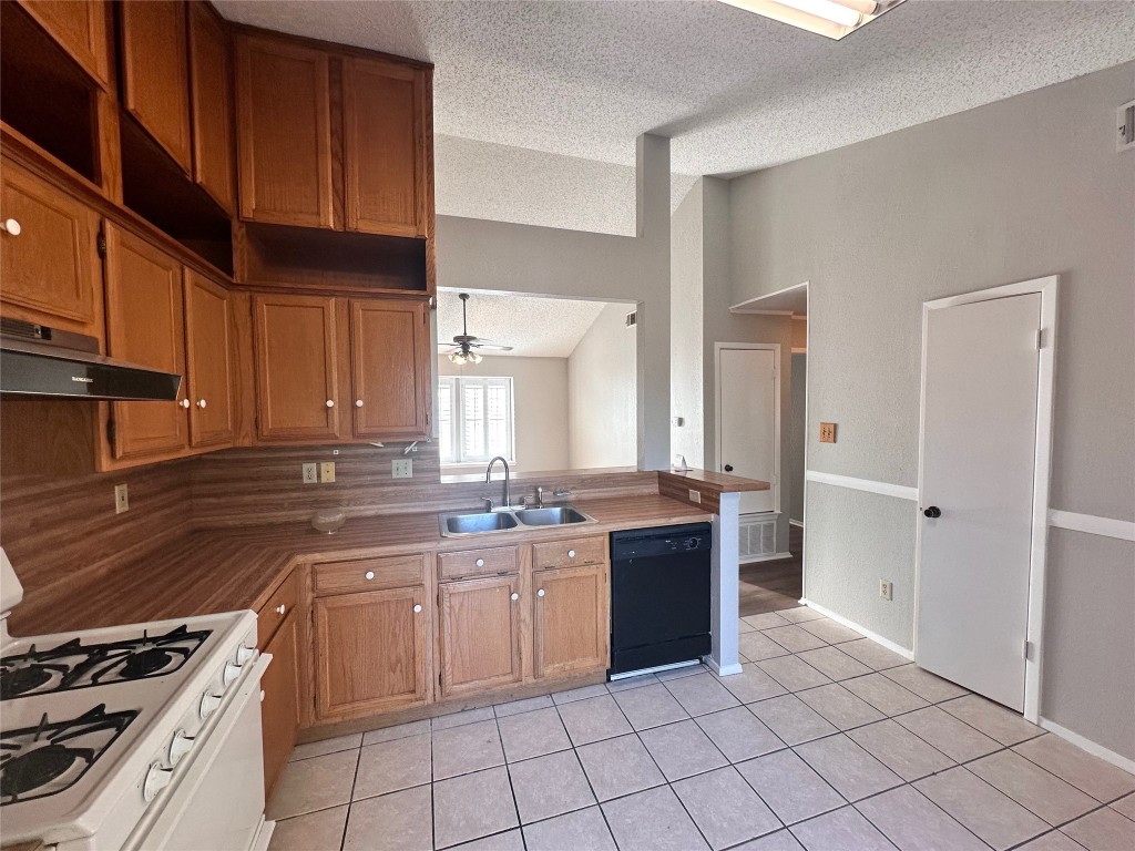 1411 Gracy Farms Lane, Unit 102 Austin, TX 78758 - Photo 6 of 12 a kitchen with a sink stove top oven and cabinets