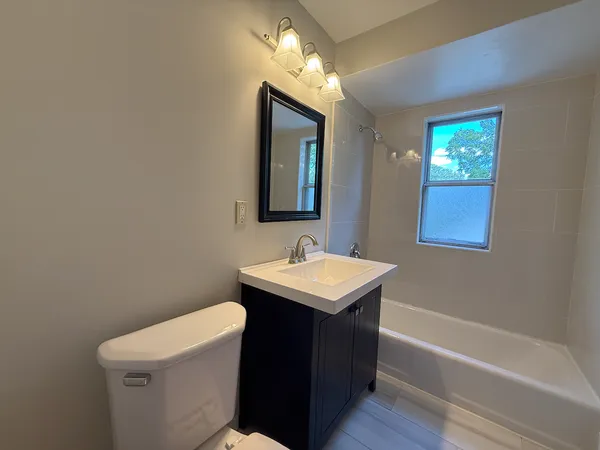 a bathroom with a sink a toilet and mirror