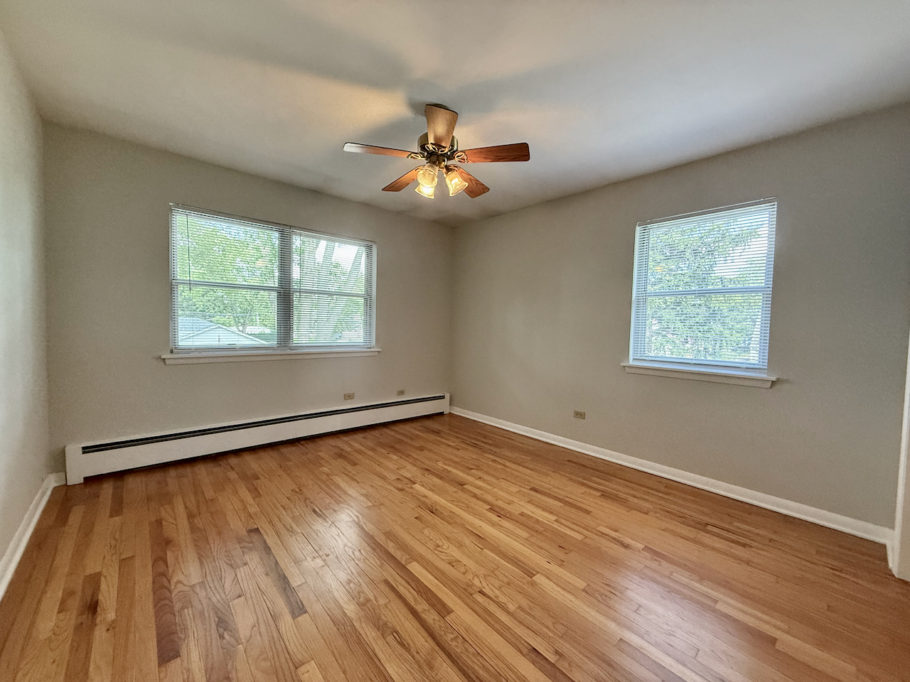 317 South Plum Grove Road, Unit 5 Palatine, IL 60067 - Photo 10 of 14 a view of an empty room with wooden floor and a window